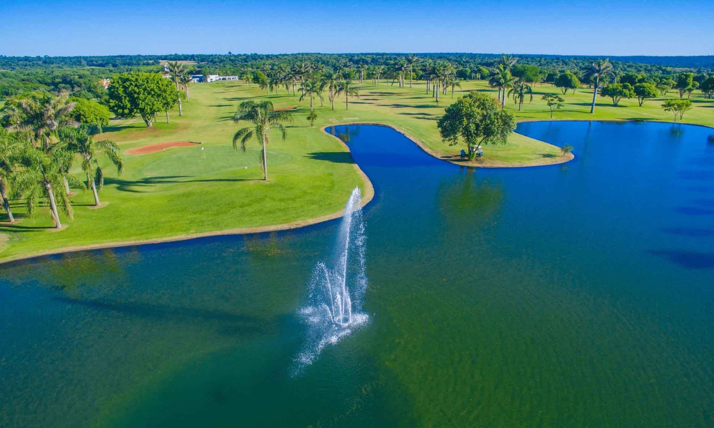 A water hazard with a fountain next to a smooth green