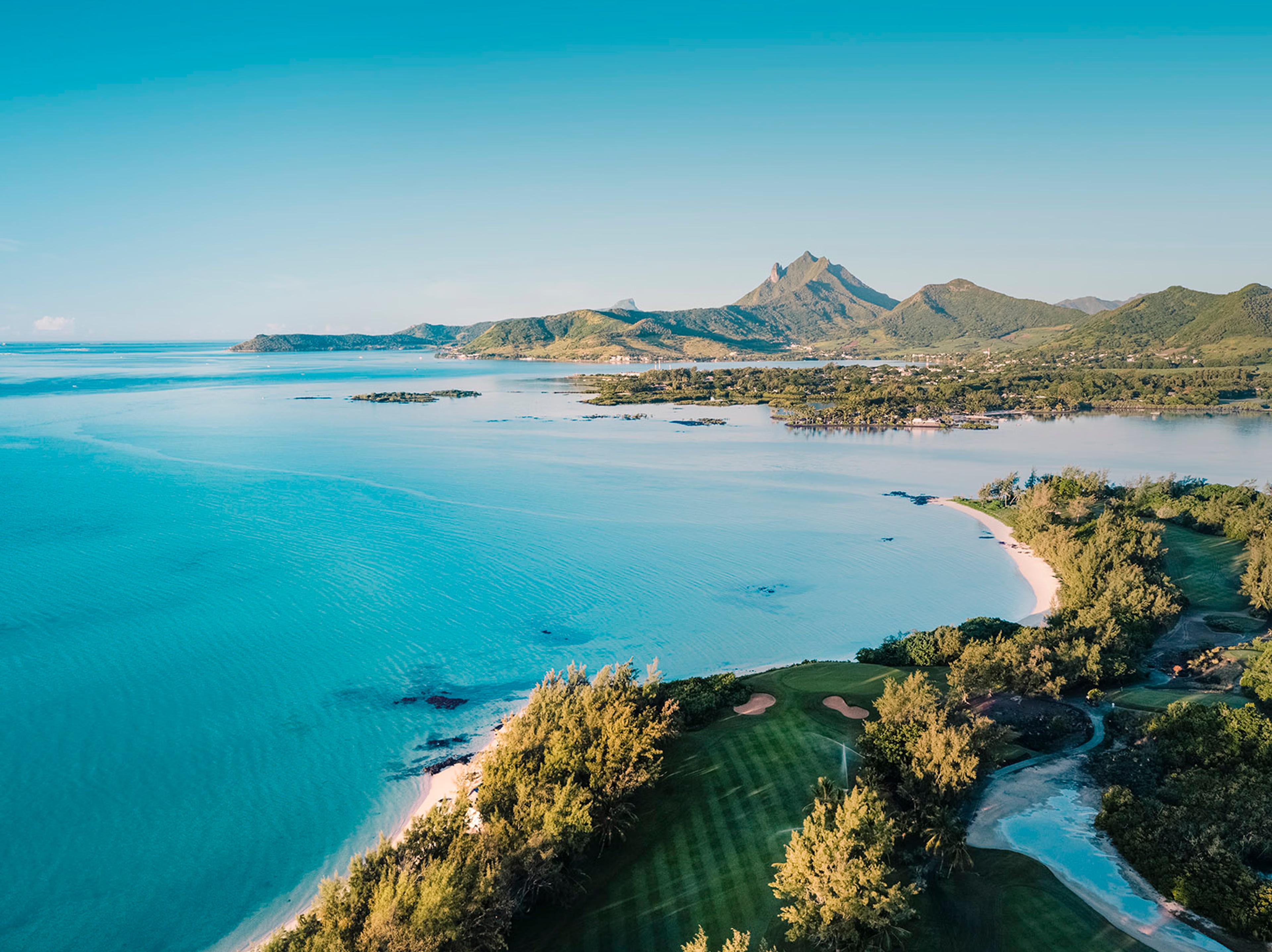 Overhead view of a well maintained fairway leading to a smooth green with coastal views