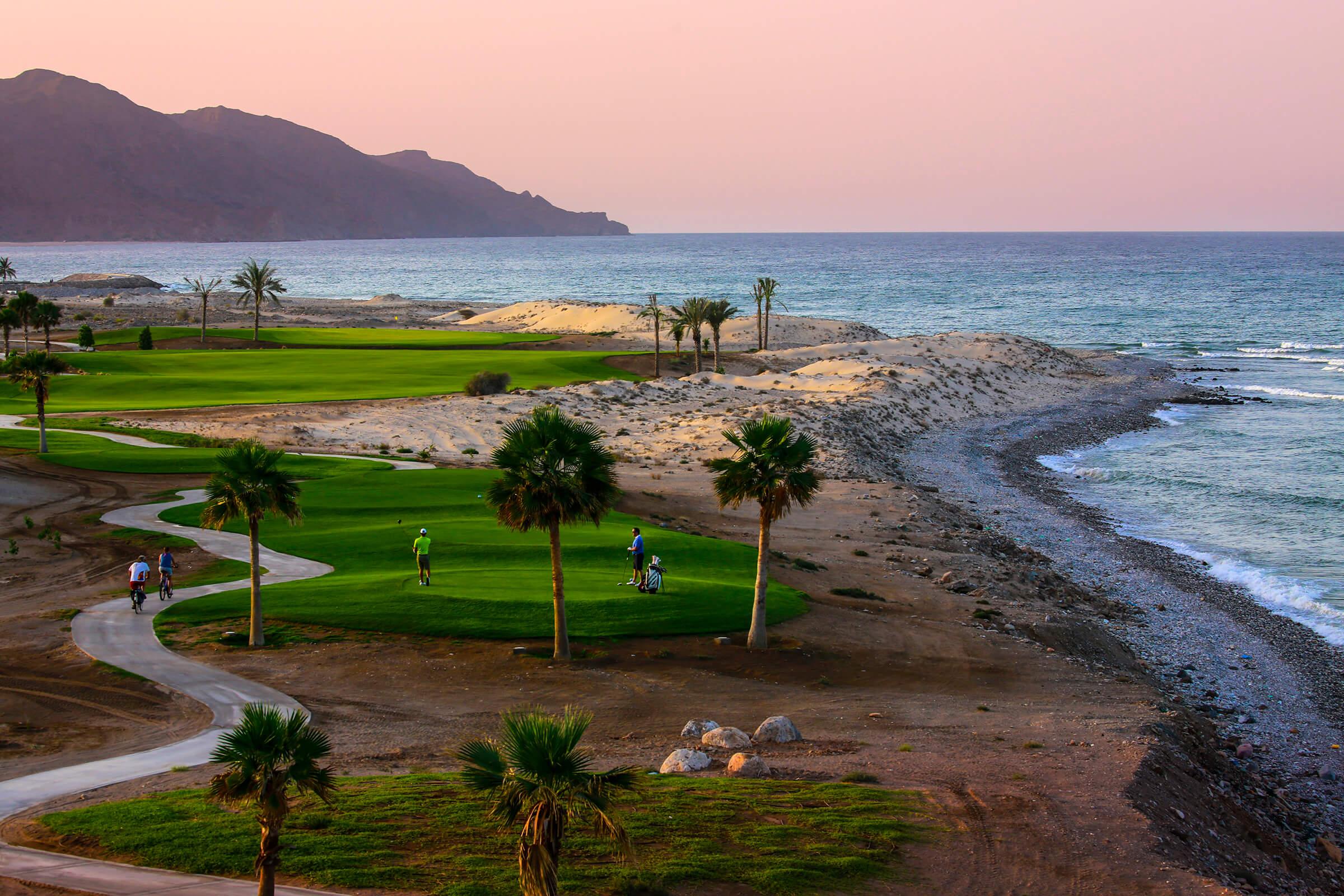Overhead view of golfers enjoying their round on a smooth tee box with coastal views