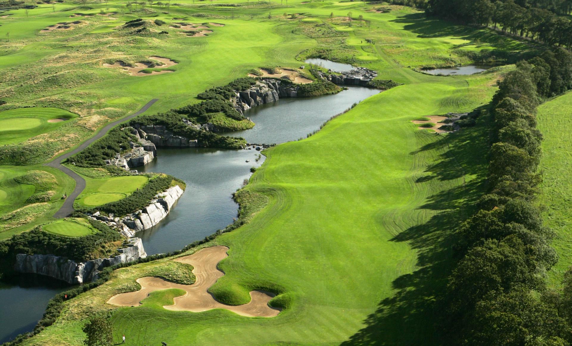 An aerial view of a dramatic championship course with rugged water features and rolling fairways.
