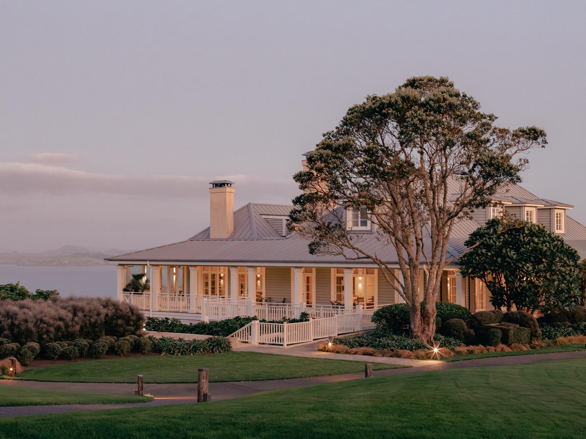 The Kauri Cliffs Resort clubhouse being lit up at evening