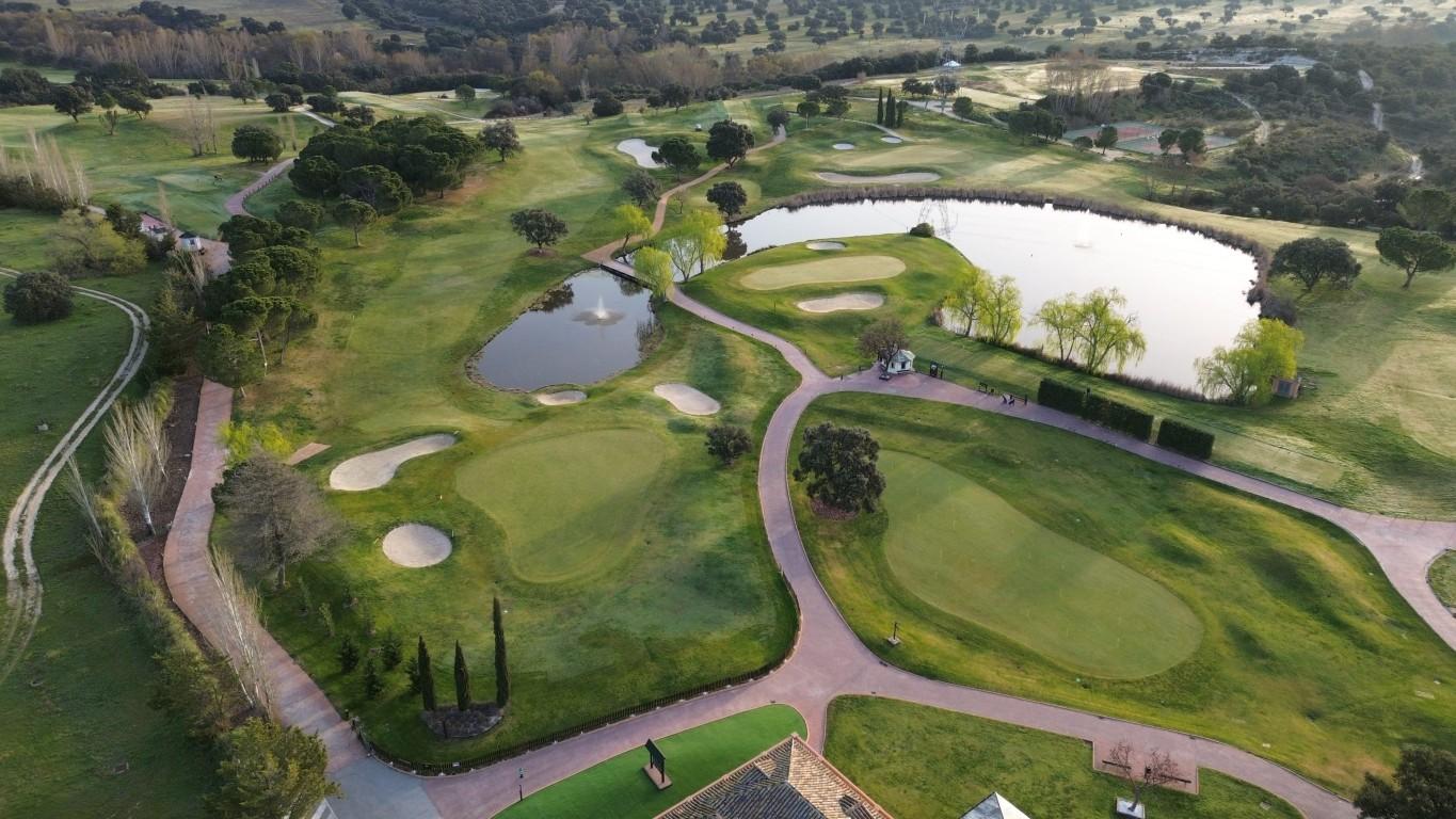 Aerial view of a golf course with several ponds, greens, and winding paths
