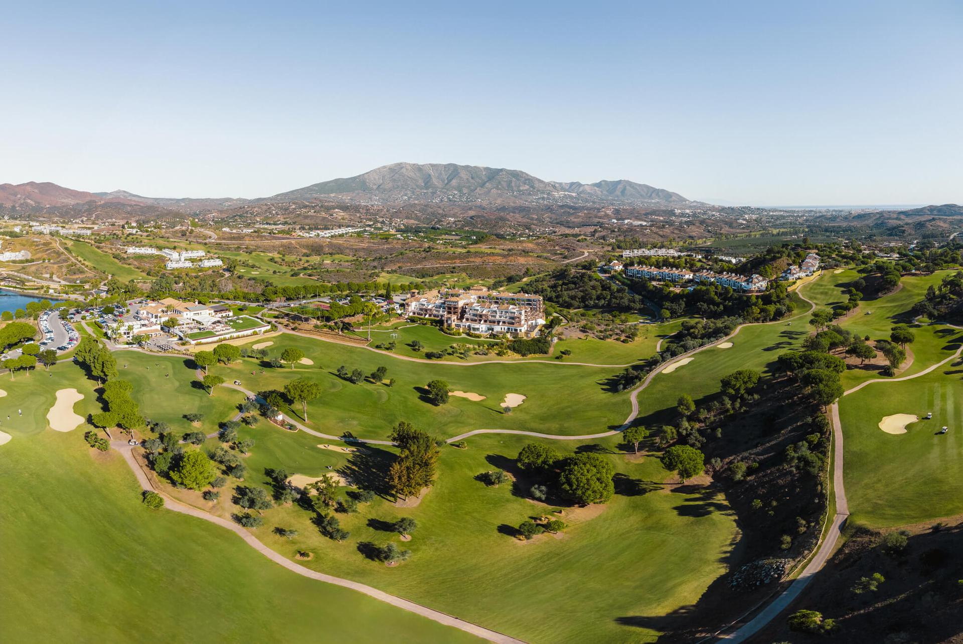Aeiral view of La Cala Golf Resort with the hotel, golf and mountains visible in the distance