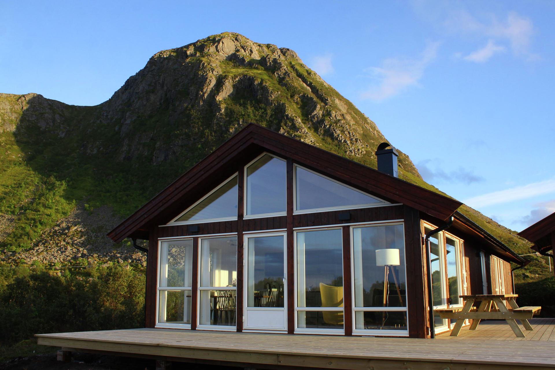 One of the Lofoten Links Lodges with a mountain towering over in the back