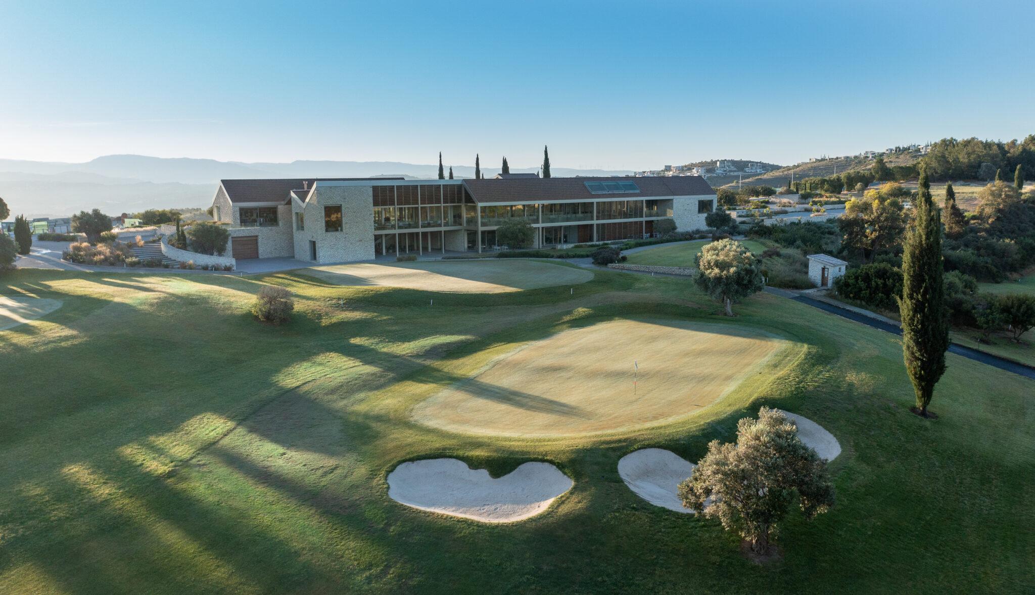 Close-up of the clubhouse, overlooking practice greens and a serene course setting.
