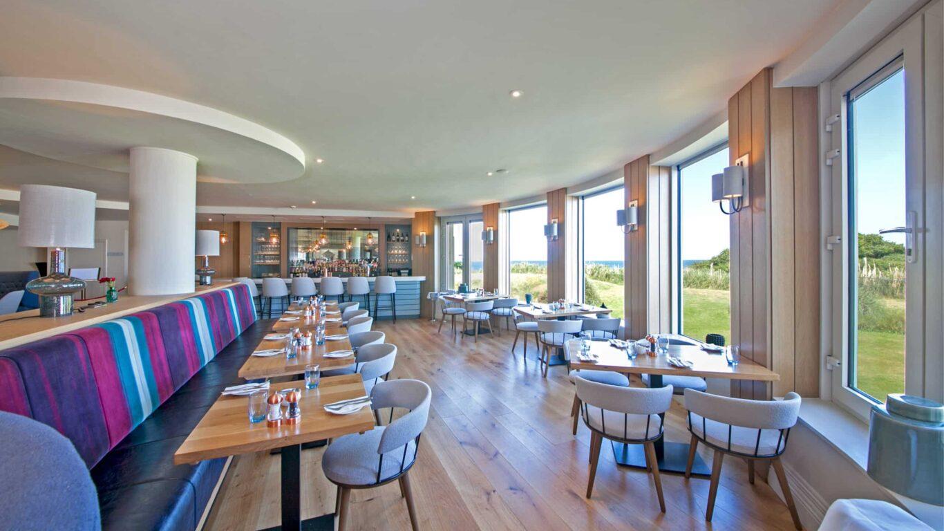 A modern restaurant with large windows and scenic outdoor views.