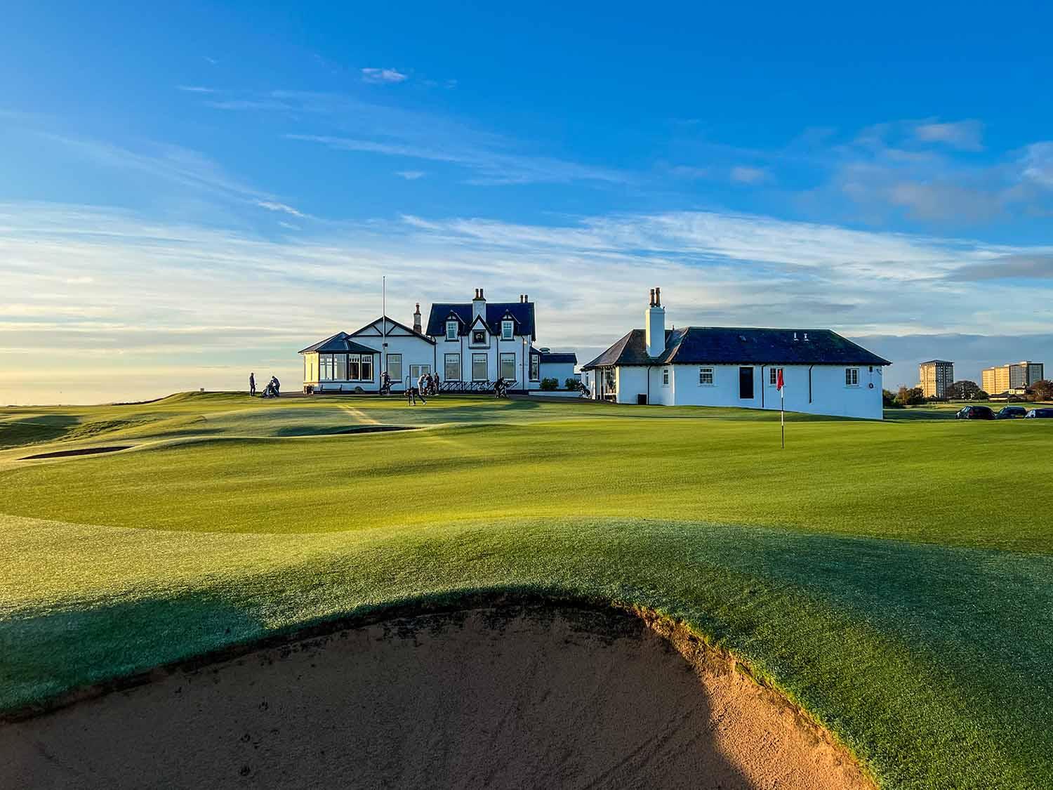 Close up view of the clubhouse looking over a sand bunker next to the green at the Royal Aberdeen Course