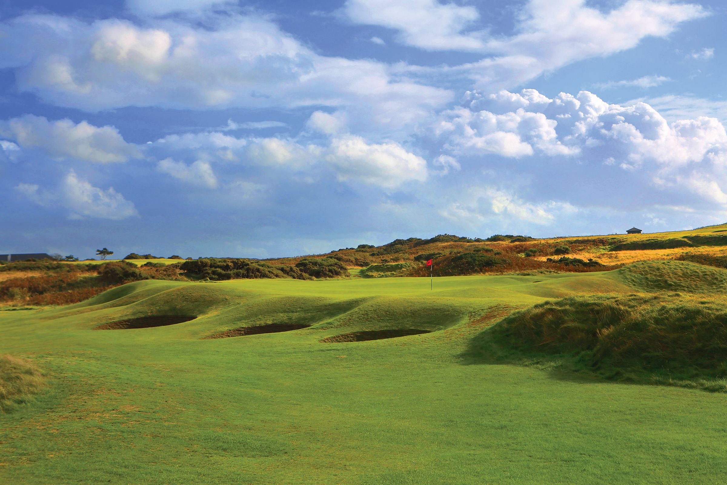 The greens at the Royal Porthcawl course with a flighstick surrounded by bunkers