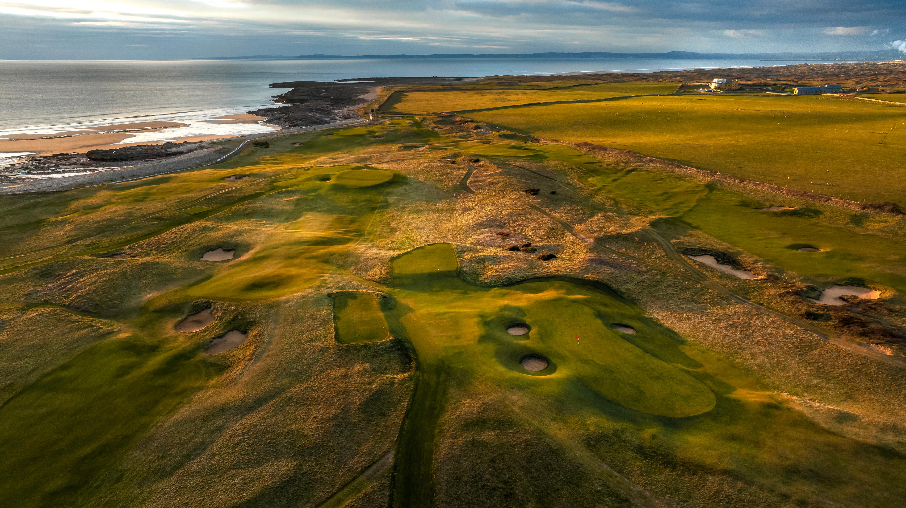 Overview of a hole at the course with manicured greens and a wonderful view