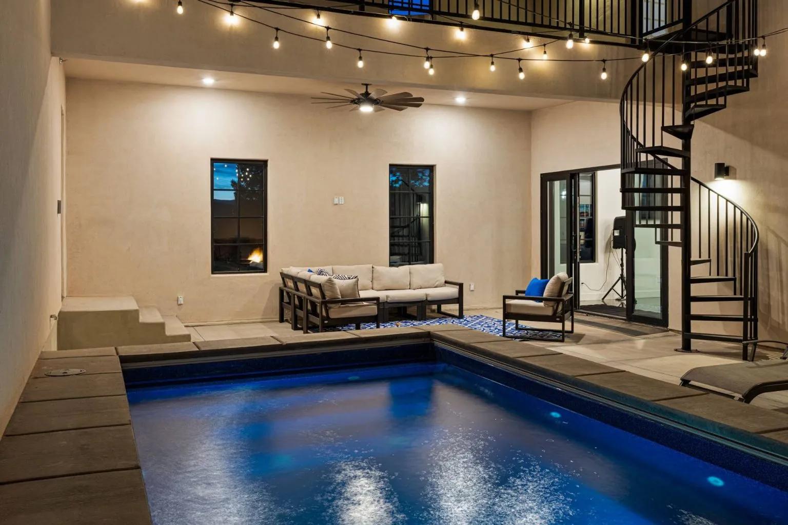 A personal pool as part of a villa at the resort featuring a poolside sofa and spiral staircase to the top floor