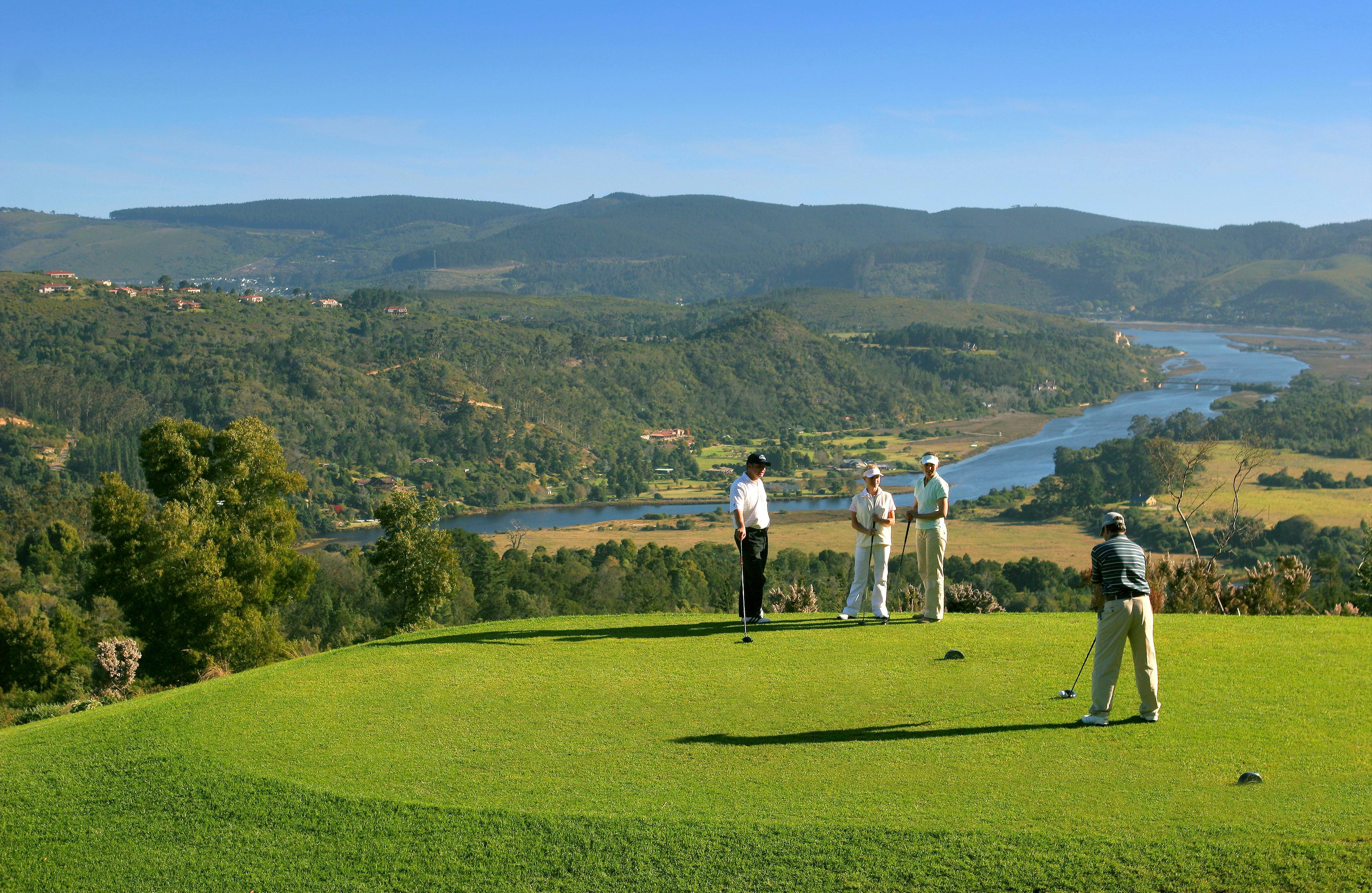 Golfers enjoying their round on a smooth green with mountain views