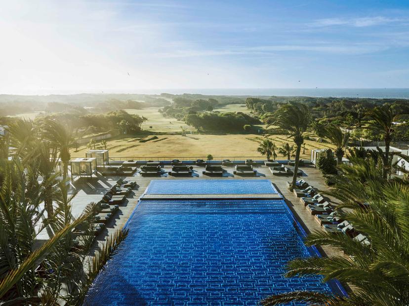 Overhead view of the sun setting over the Sofitel Essaouira Mogador Golf & Spa swimming pool