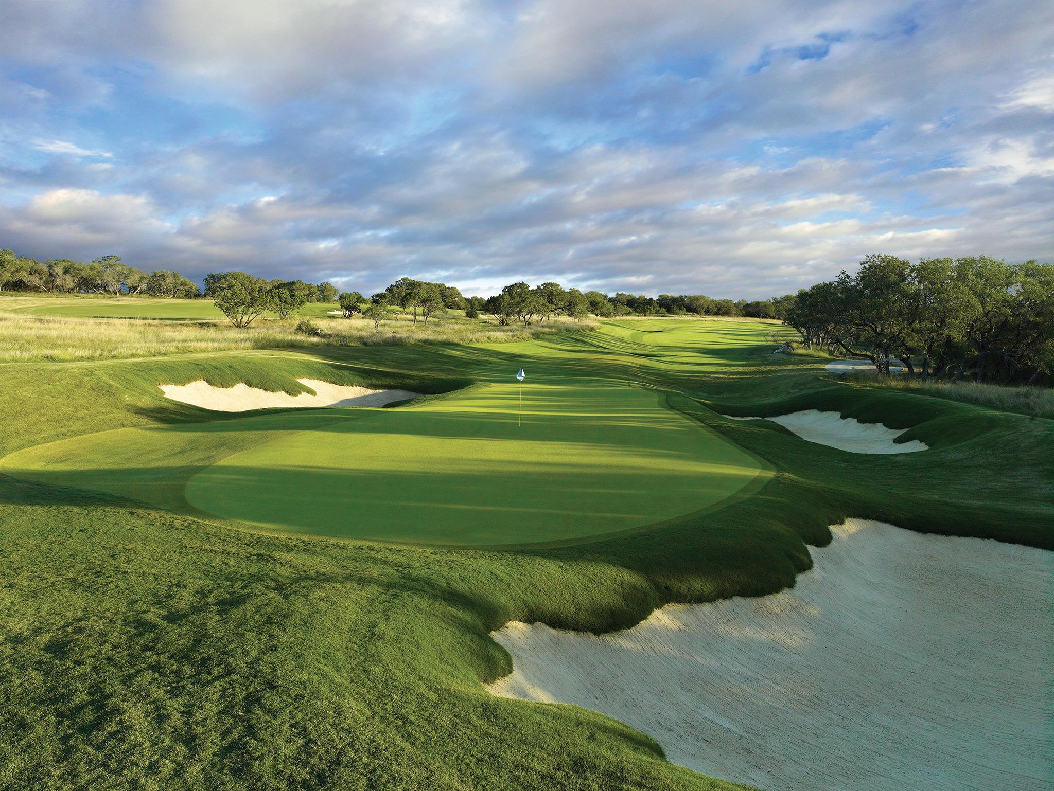 Strategic championship green framed by challenging bunkers and rolling fairways.