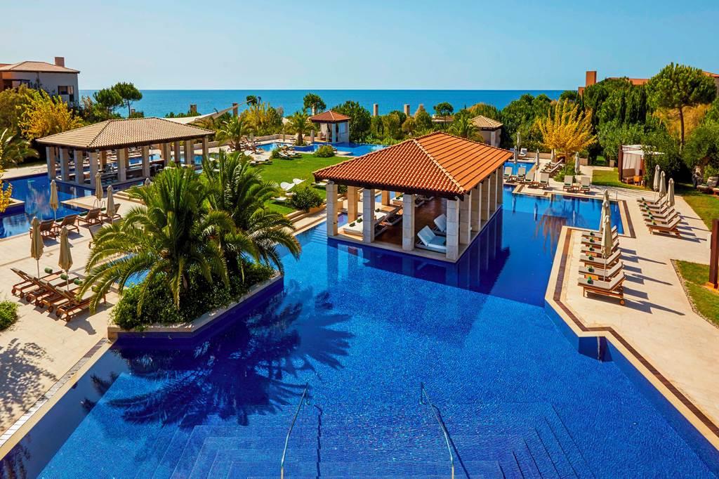 Outdoor swimming pool open to all guests with cabanas placed around with sun beds