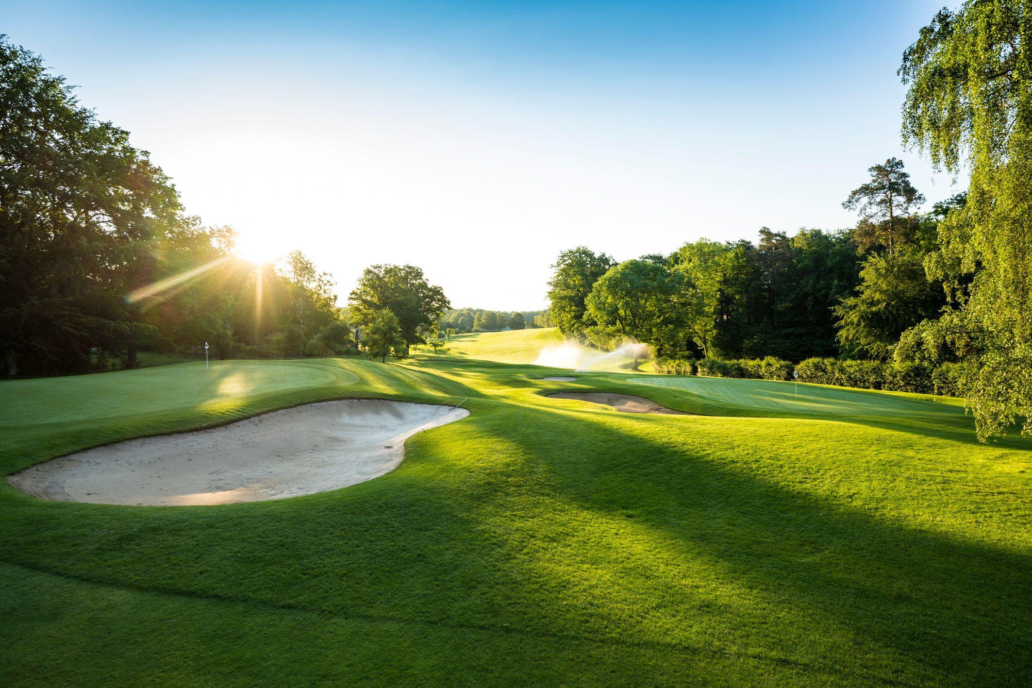 Sand bunkers and smooth greens glow in the evening light.