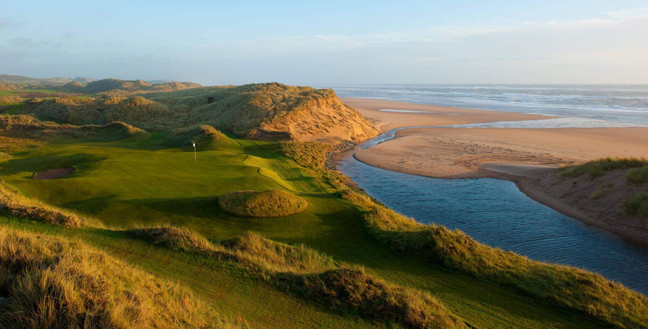 A stunning golf hole sits beside a sandy beach and winding stream.