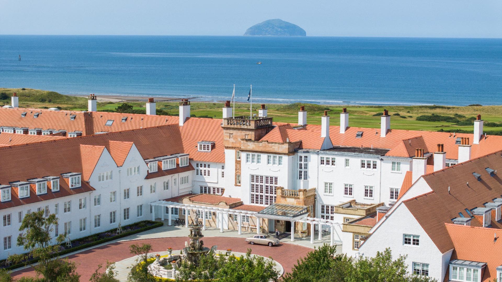 The Trump Turnberry hotel overlooking the sea, with its striking architecture and red rooftops.