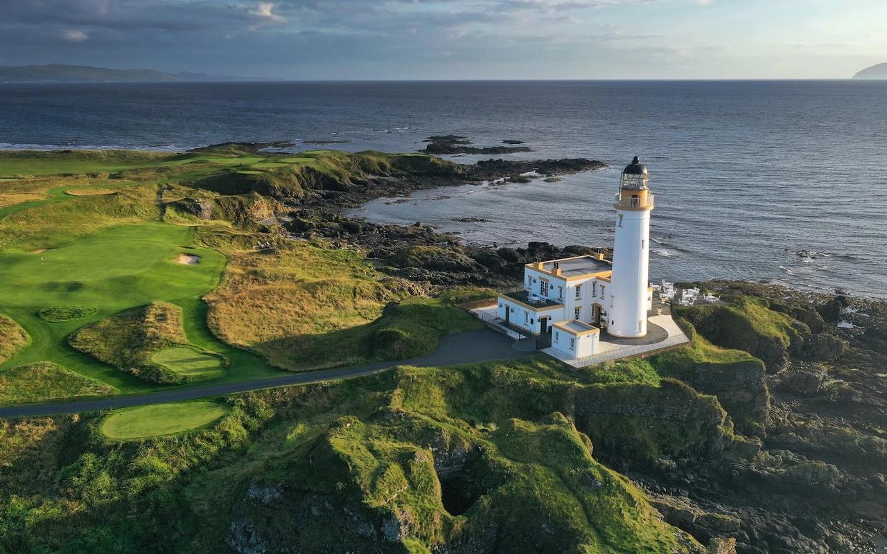 A close-up aerial view of the iconic Turnberry lighthouse by the rocky shore.