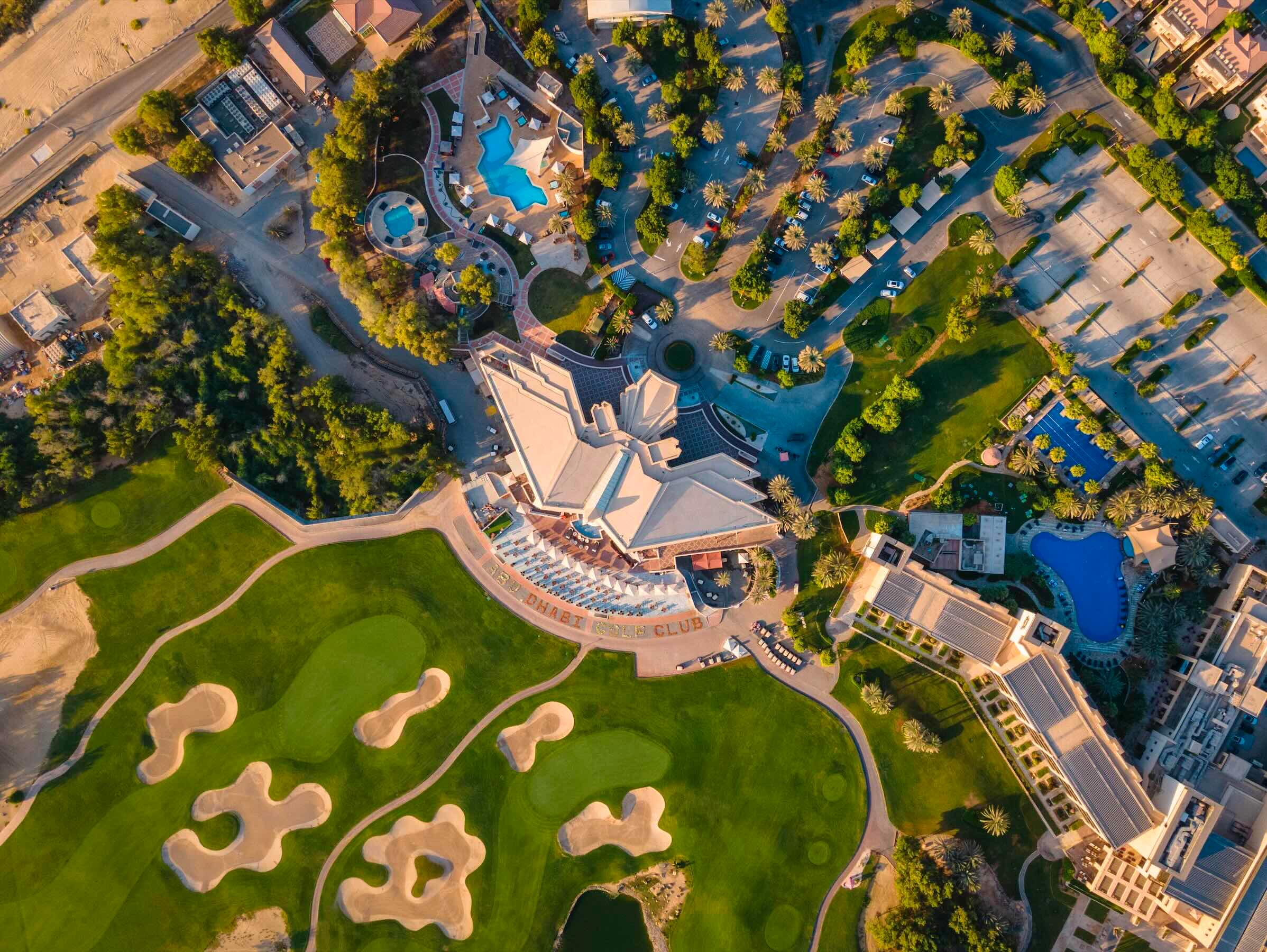 Aerial view of the VOGO Abu Dhabi Golf Resort & Spa building and its golf course