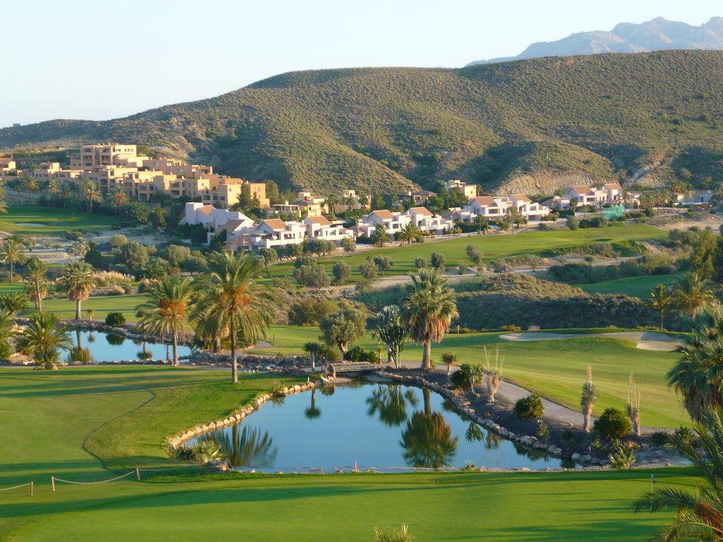 Winding fairways interspersed with bunkers and water hazards with hills in the background