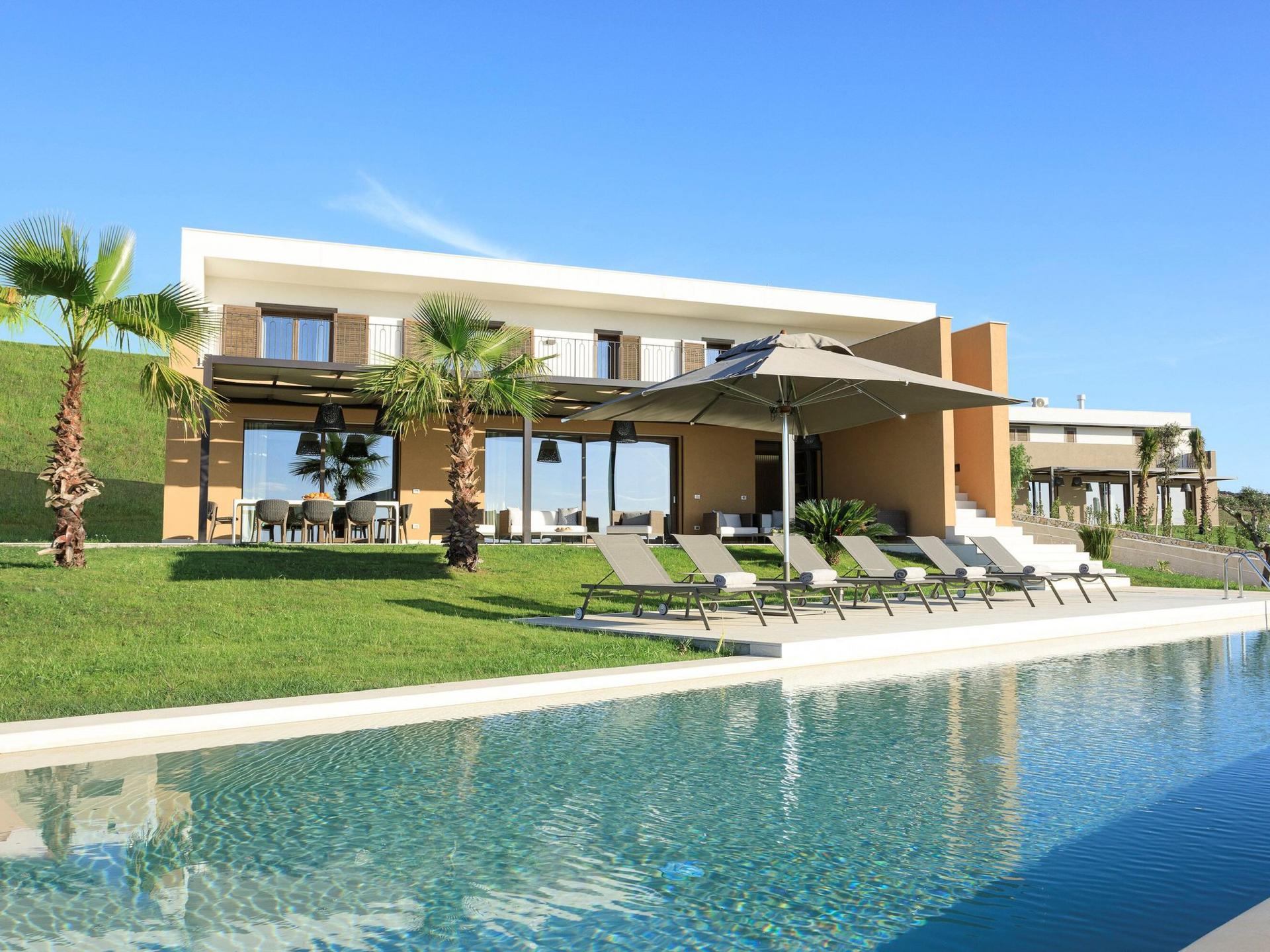 A villa at the resort with an outdoor dining area alongside a personal pool