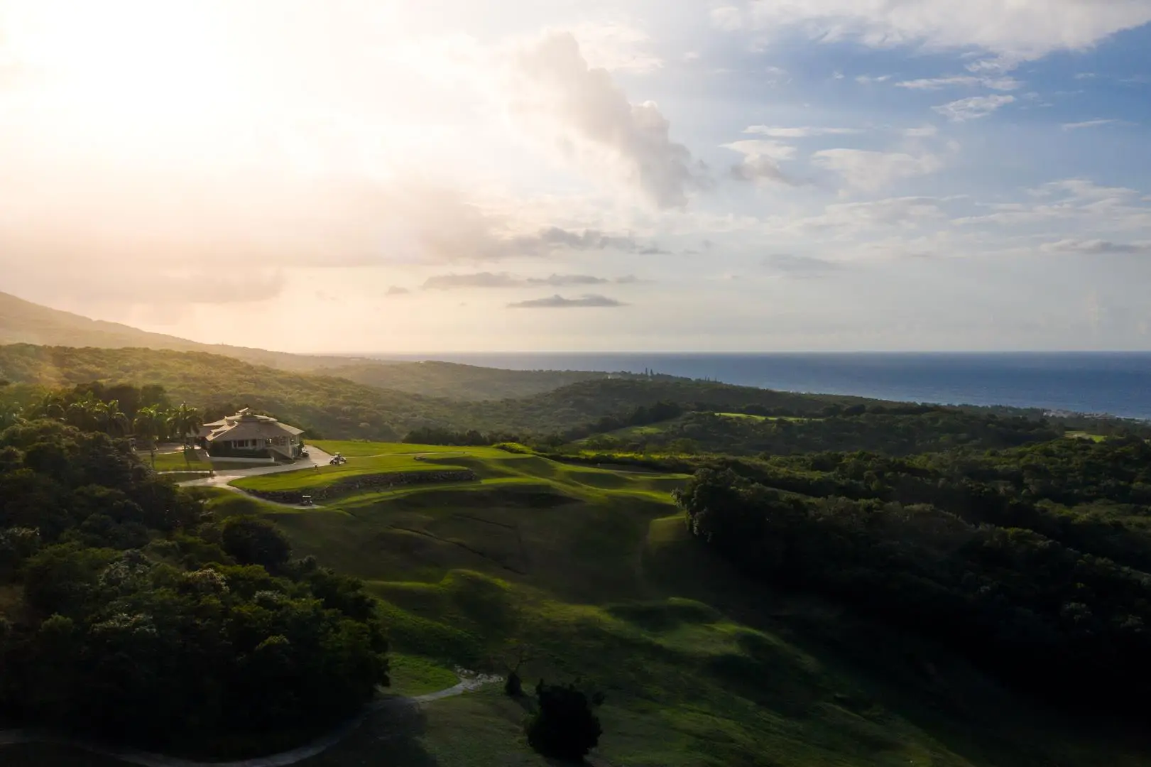 A dramatic landscape surrounds the clubhouse with rolling hills and coastal views.