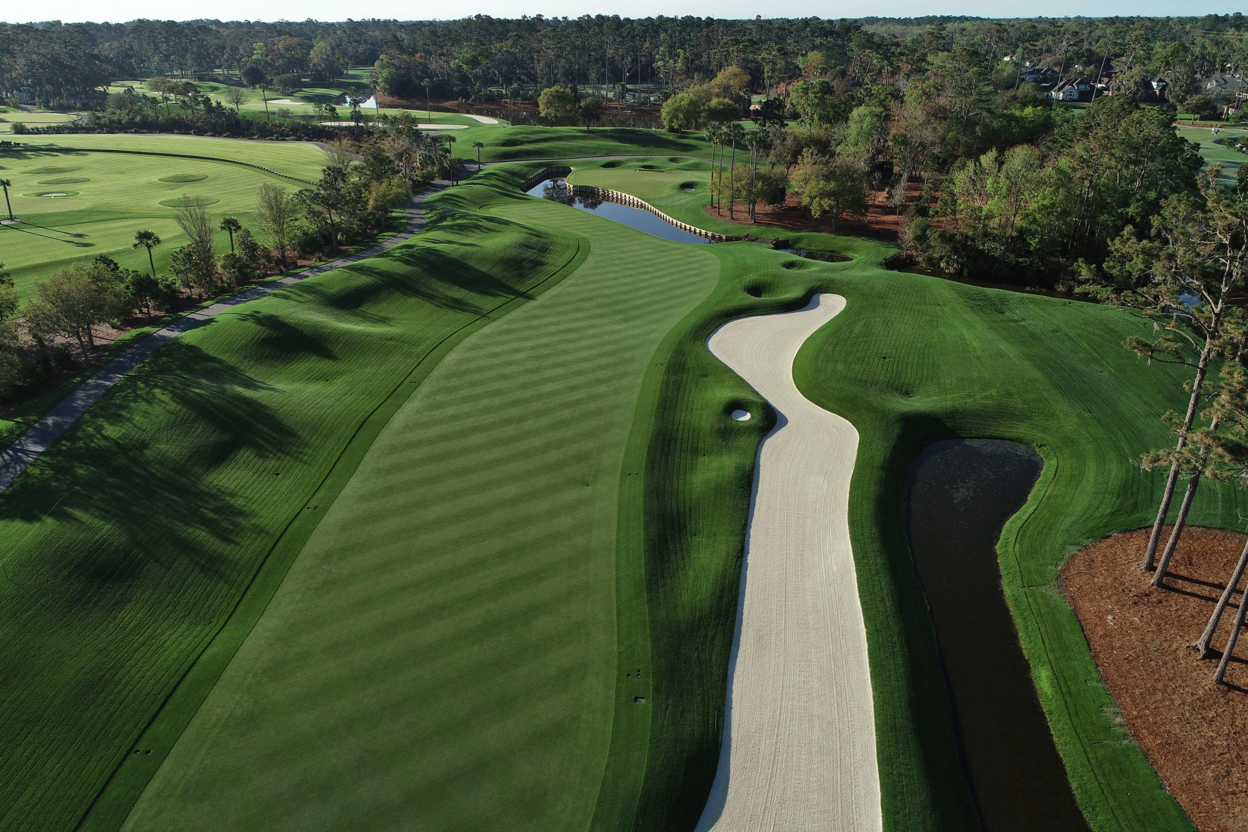 Birdseye view of a wide fairway running next to a large sand bunker