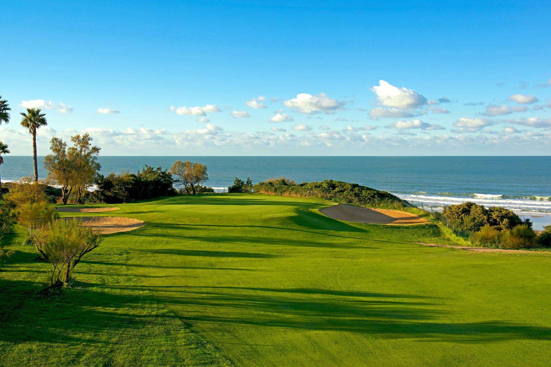 Panoramic view of a coastal green surrounded by sand bunkers