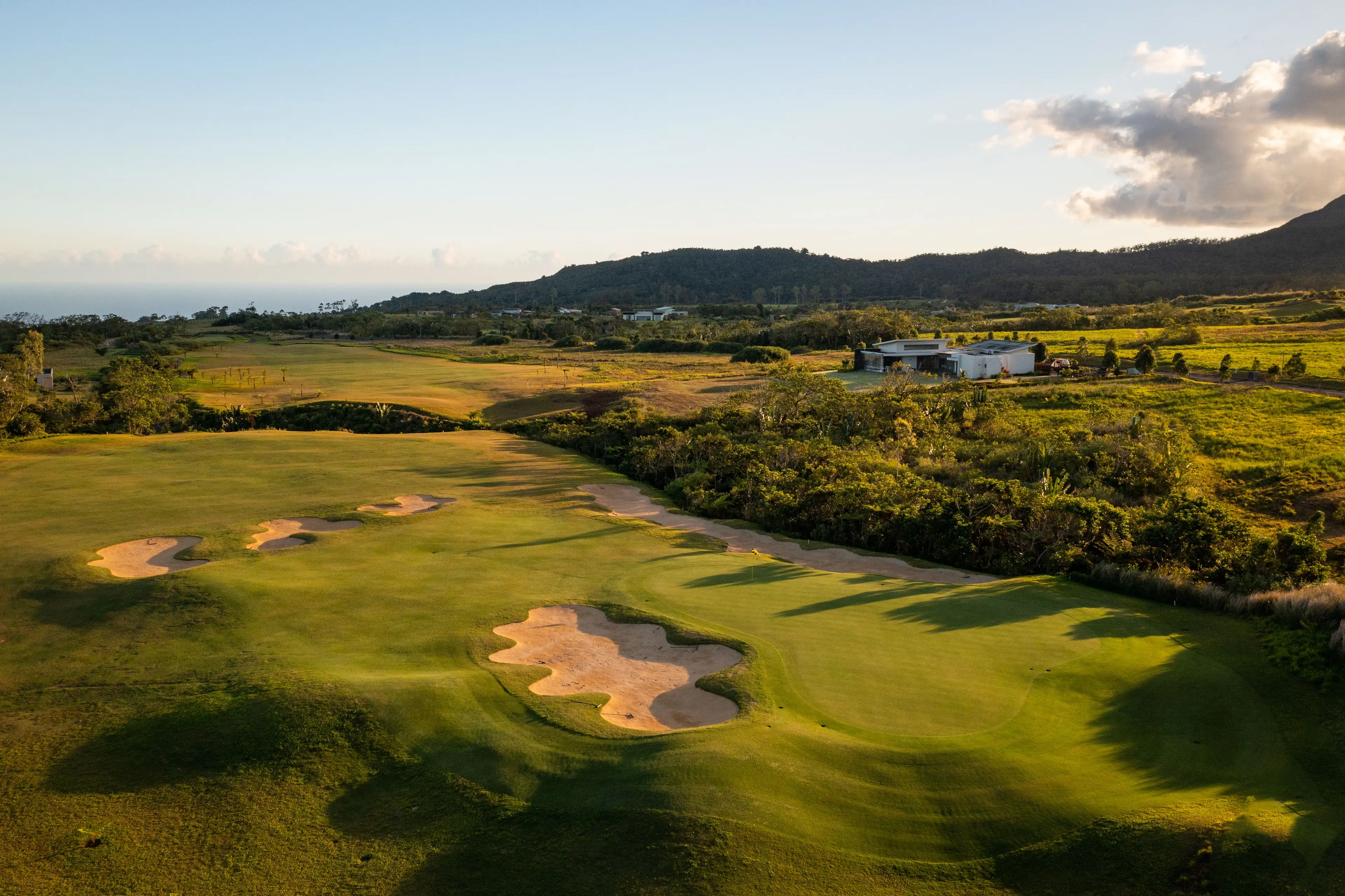Panoramic view of a smooth green surrounded by sand bunkers